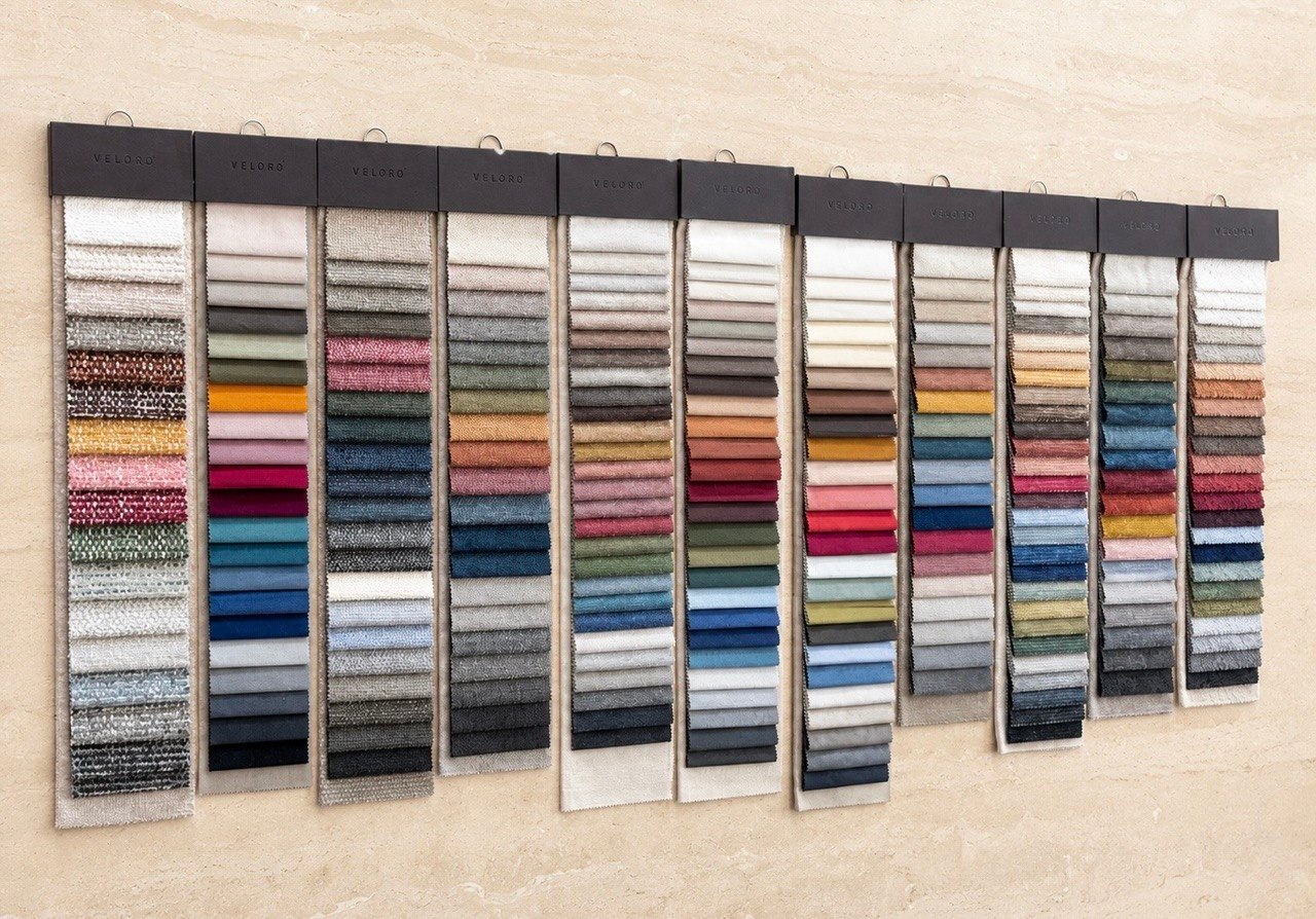 Full wall of Veloro bespoke sofa fabric sample books in the Dominus Design studio