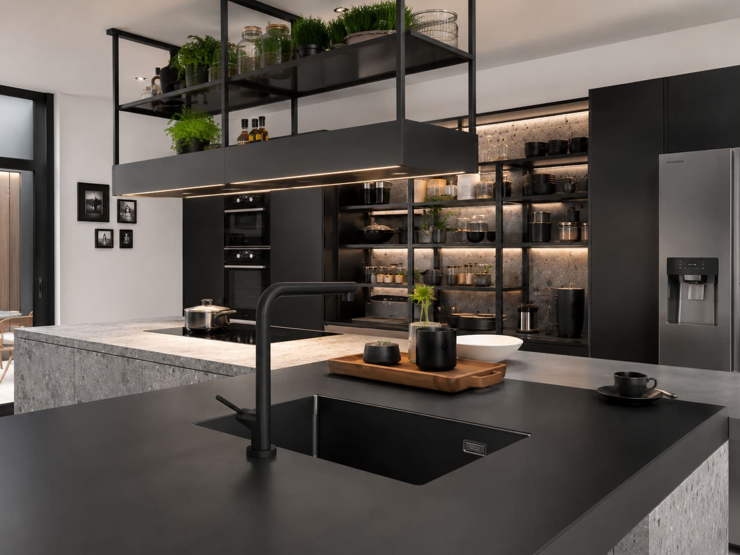 Industrial black bespoke kitchen with overhead shelving and dark stone worktops