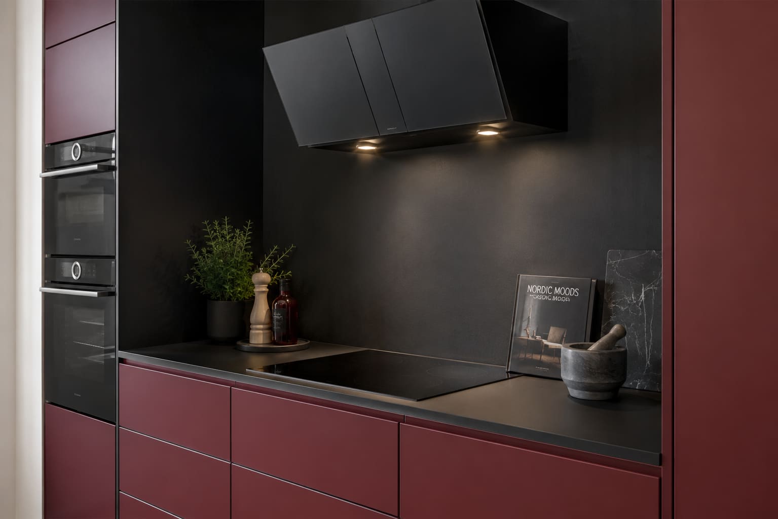 Detail shot of the same oxide-red bespoke kitchen with matte black hob wall